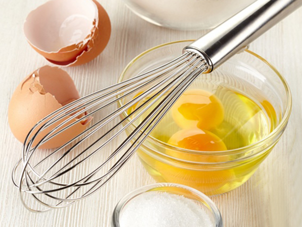 Ingredients for baking cake on white wooden background